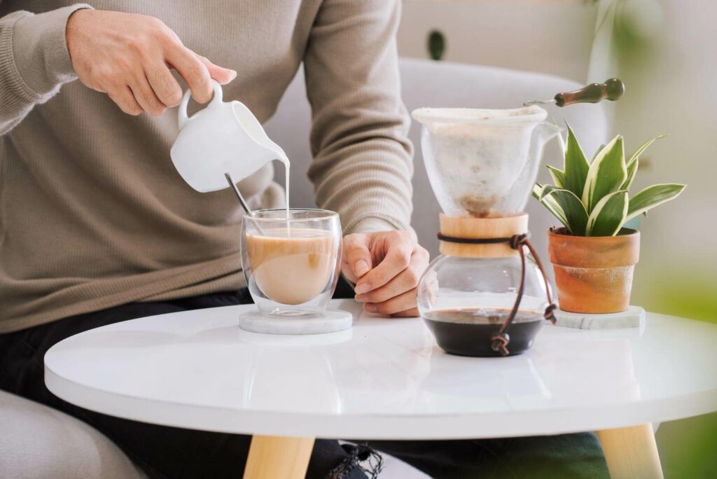 Man pouring milk into coffee cup